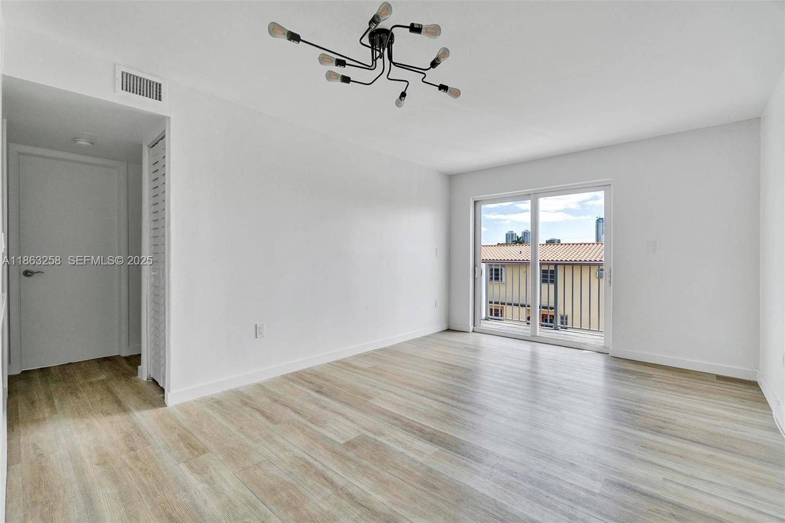620 Southwest 10th Street, Unit 405 Miami, FL 33130 - Photo 6 of 21 wooden floor in an empty room with a window