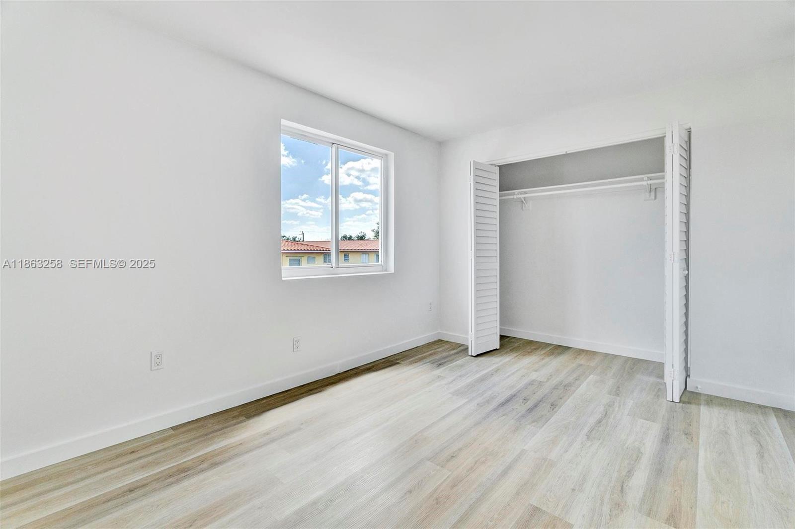 620 Southwest 10th Street, Unit 405 Miami, FL 33130 - Photo 9 of 21 an empty room with wooden floor and windows