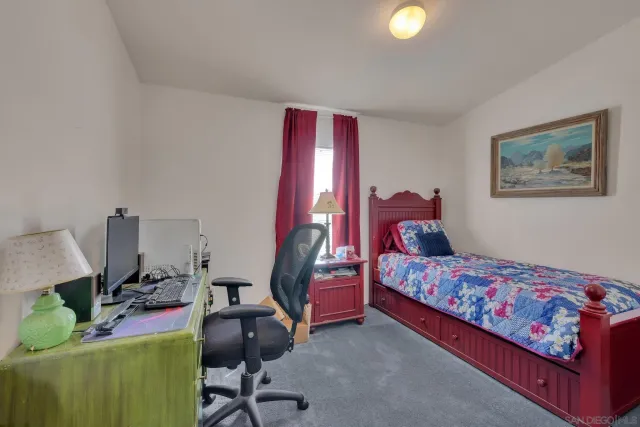 a bedroom with a bed and a workspace