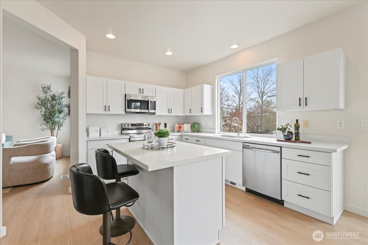 401 Graham Avenue Northeast Renton, WA 98059 - Photo 11 of 40 a kitchen with a sink dishwasher a stove a refrigerator and cabinets with wooden floor