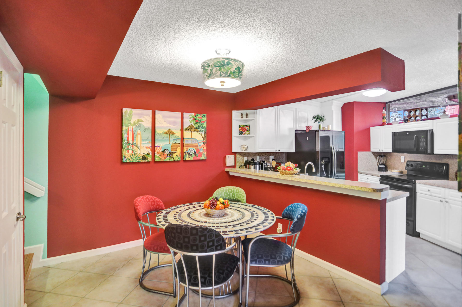 8057 Severn Drive, Unit A Boca Raton, FL 33433 - Photo 12 of 33 a dining room with a table chairs and a kitchen view