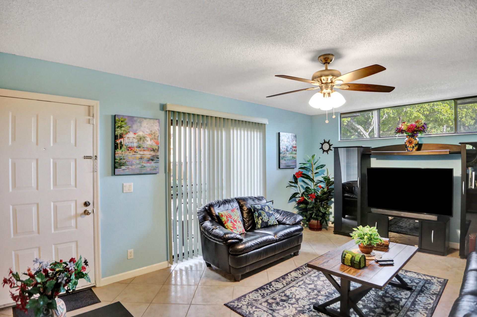 8057 Severn Drive, Unit A Boca Raton, FL 33433 - Photo 4 of 33 a living room with furniture a flat screen tv and a fireplace