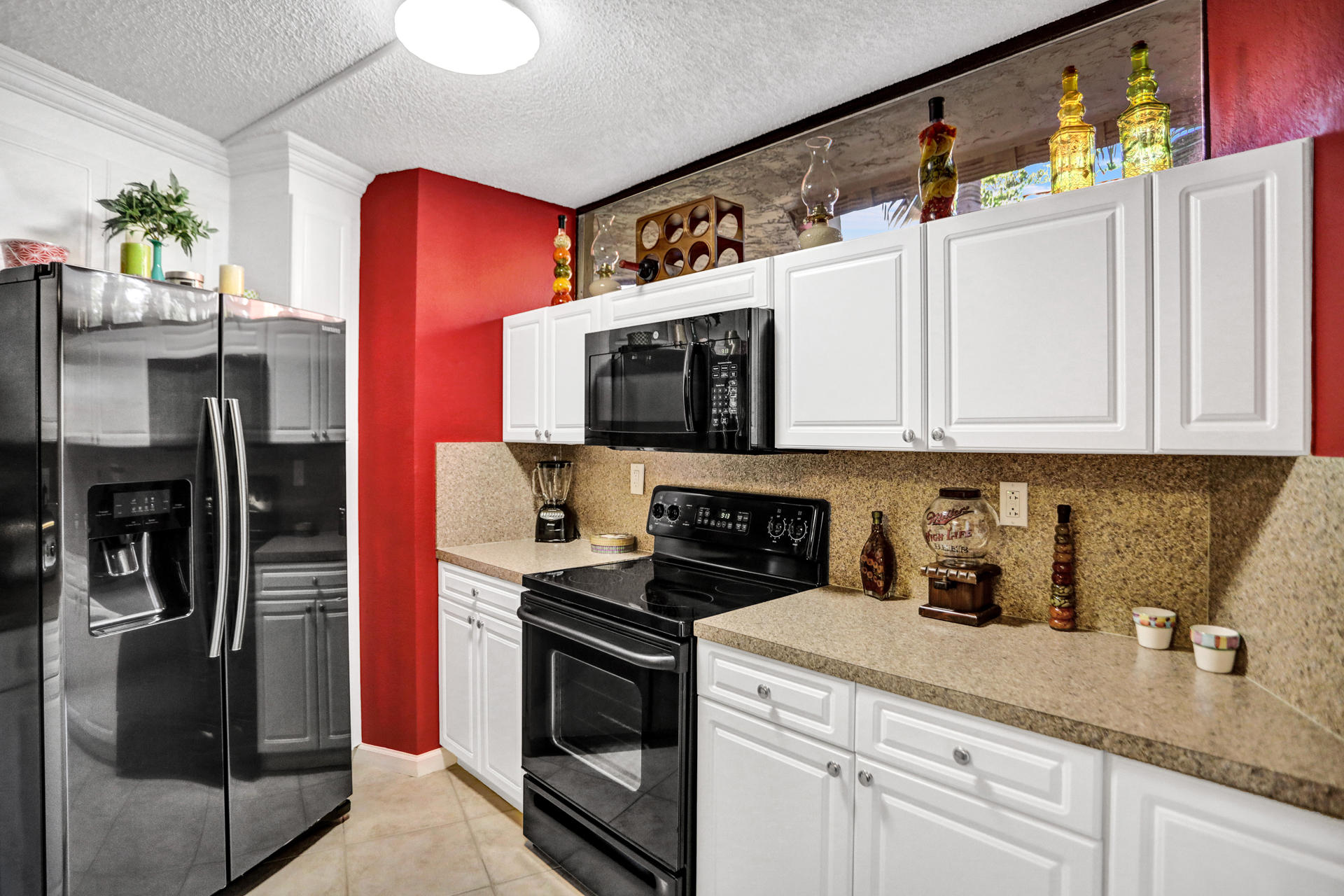 8057 Severn Drive, Unit A Boca Raton, FL 33433 - Photo 5 of 33 a kitchen with stainless steel appliances granite countertop a refrigerator and a stove top oven