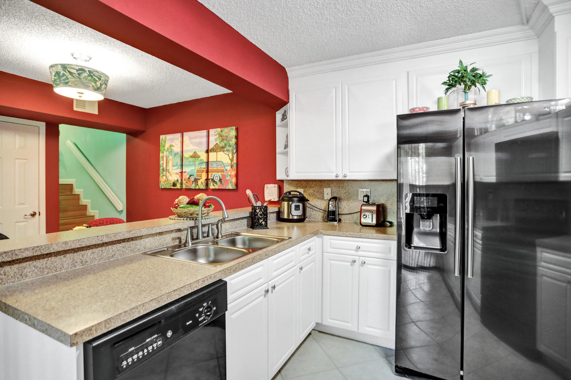 8057 Severn Drive, Unit A Boca Raton, FL 33433 - Photo 6 of 33 a kitchen with a sink stainless steel appliances and white cabinets