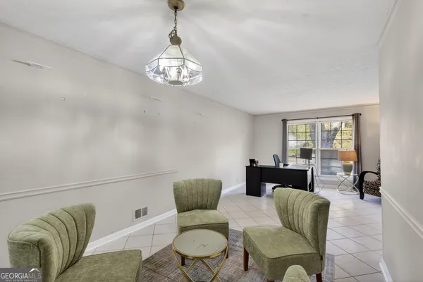 a living room with furniture and a chandelier