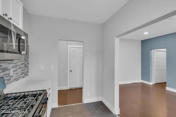 a view of a livingroom with wooden floor and kitchen space