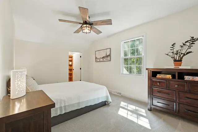 a bedroom with a bed and a ceiling fan