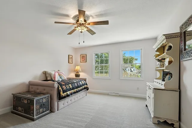 a living room with furniture and a ceiling fan
