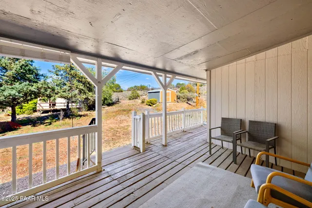 a view of a porch with furniture and a yard