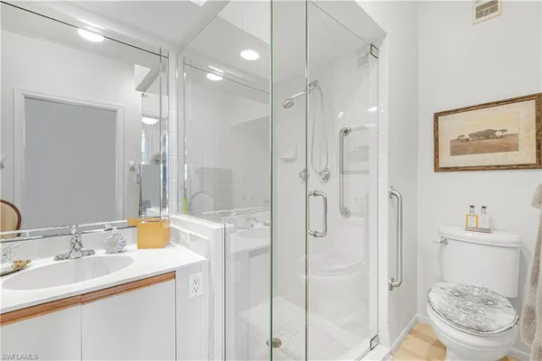 a bathroom with a granite countertop sink toilet a shower and a mirror