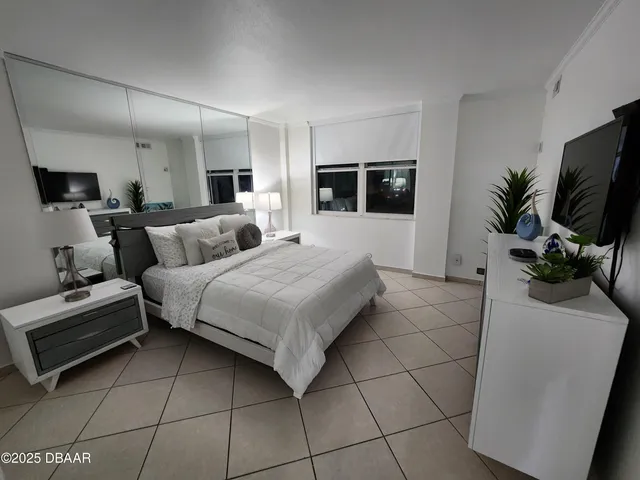 a large bedroom with a bed a rug and fireplace