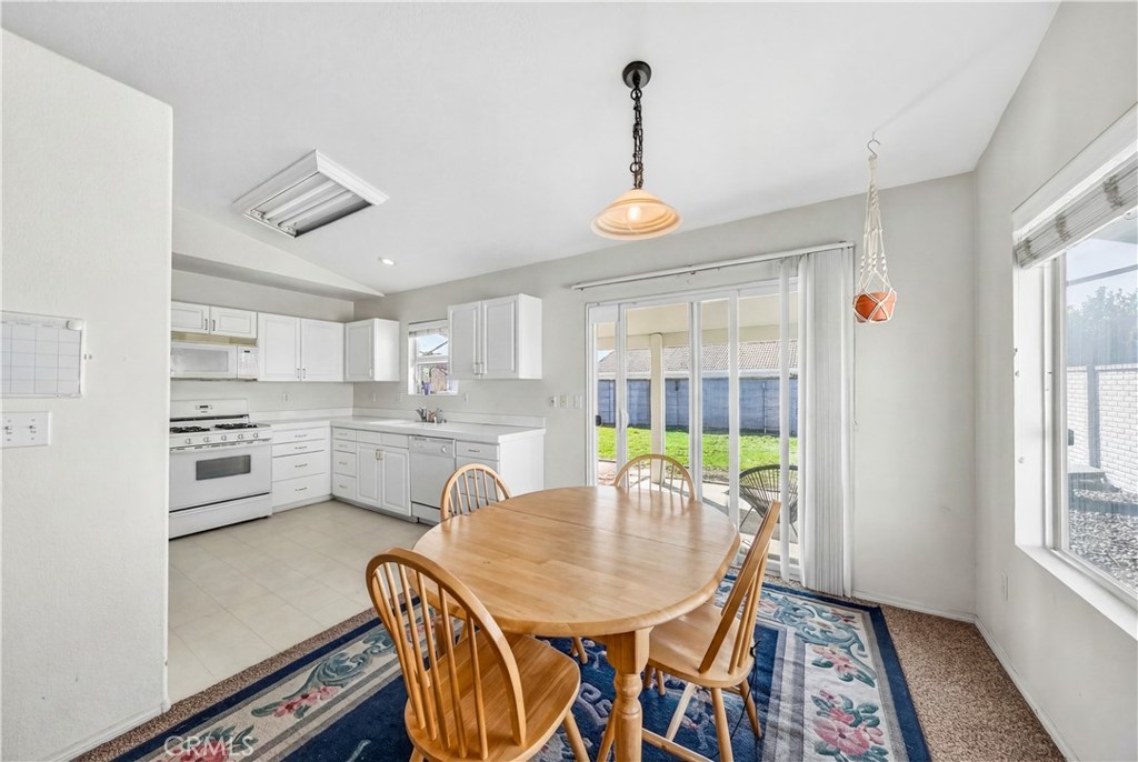 2995 Joshua Way Hemet, CA 92545 - Photo 19 of 34 a view of a dining room and livingroom with furniture wooden floor a rug a painting and a chandelier