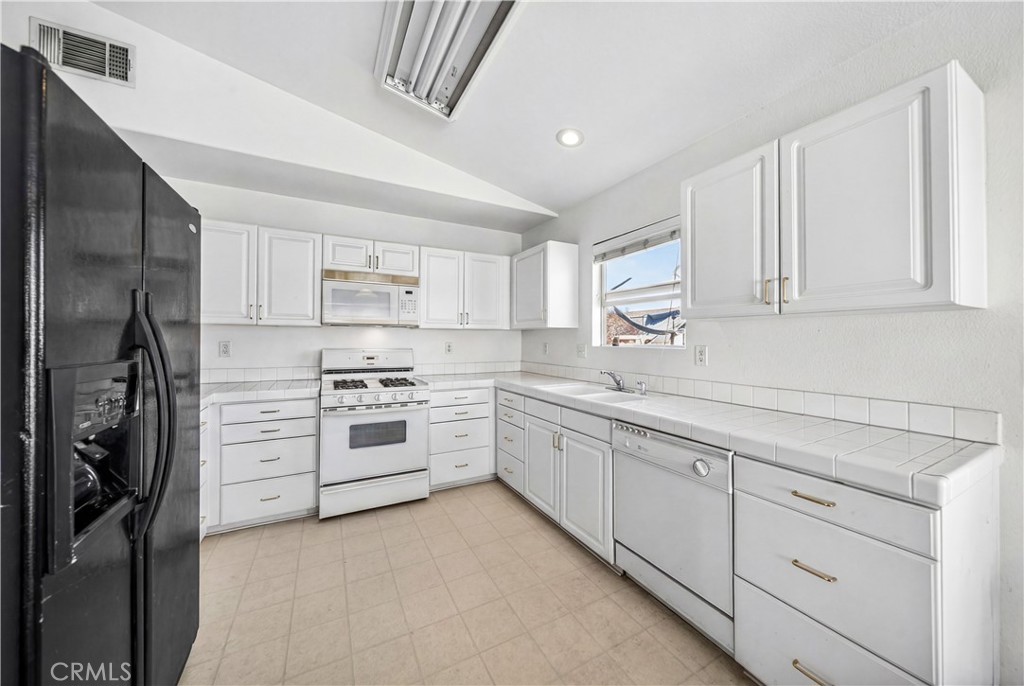 2995 Joshua Way Hemet, CA 92545 - Photo 22 of 34 a kitchen with white cabinets and stainless steel appliances
