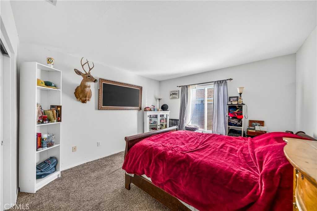 2995 Joshua Way Hemet, CA 92545 - Photo 29 of 34 a bed room with a bed a flat screen tv and a bookshelf