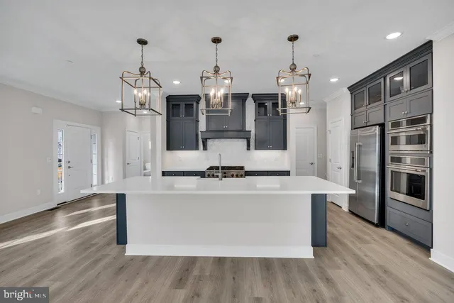 a kitchen with stainless steel appliances a stove top oven and refrigerator
