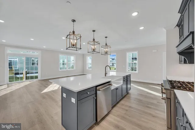 a kitchen with kitchen island granite countertop a stove and a sink