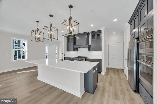 a large kitchen with kitchen island a stove a sink a refrigerator and windows