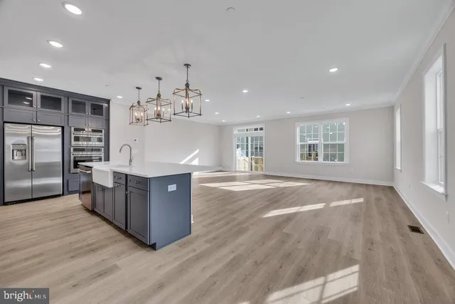 a kitchen with stainless steel appliances granite countertop a stove and a wooden floors