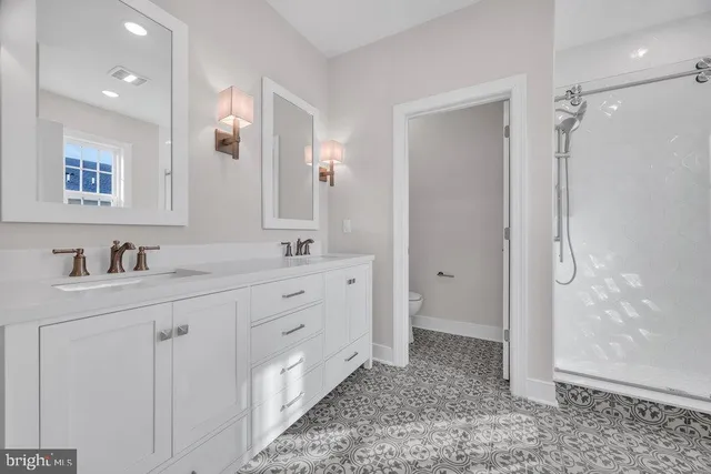 a spacious bathroom with double sink and a mirror