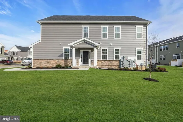 a front view of a house with a yard and green space