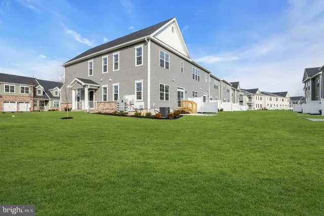 a front view of a house with a yard and trees