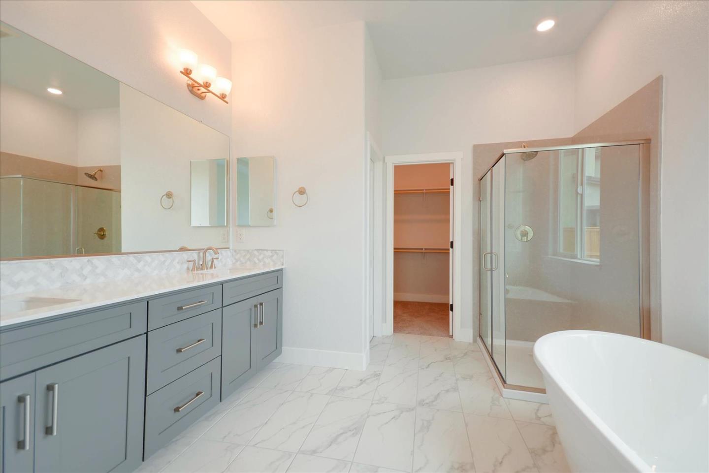 8157 Poppy Ridge Road Elk Grove, CA 95757 - Photo 30 of 42 a spacious bathroom with a double vanity sink a large mirror and a shower