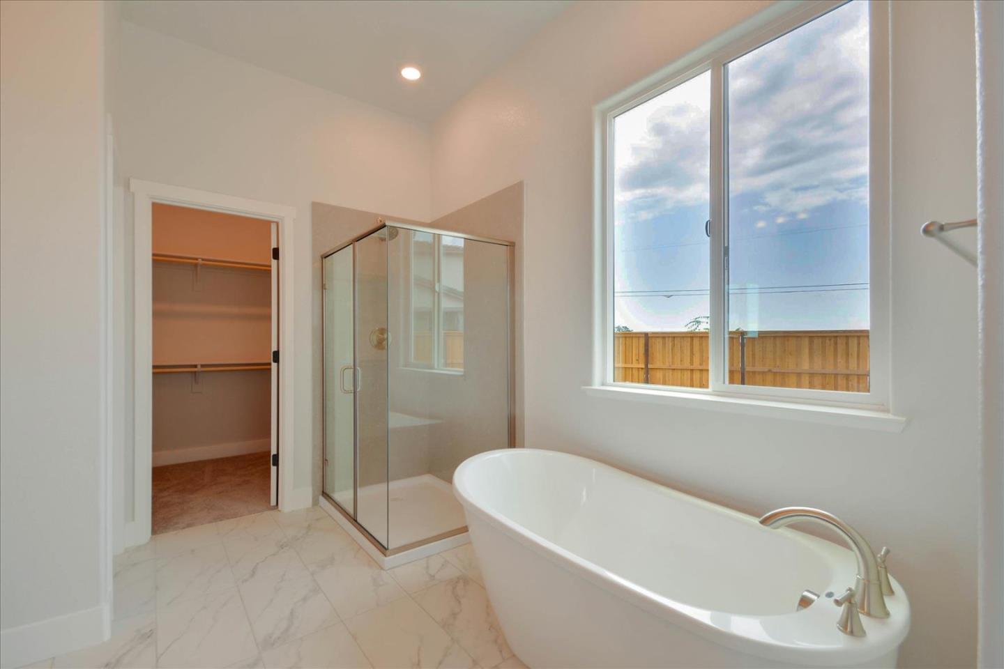 8157 Poppy Ridge Road Elk Grove, CA 95757 - Photo 31 of 42 a bathroom with a bathtub and a shower