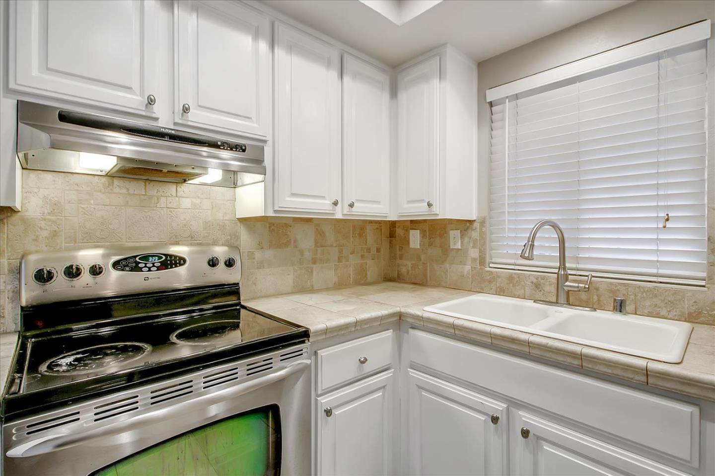 275 Shadow Dance Drive San Jose, CA 95110 - Photo 11 of 31 a kitchen with a stove and white cabinets