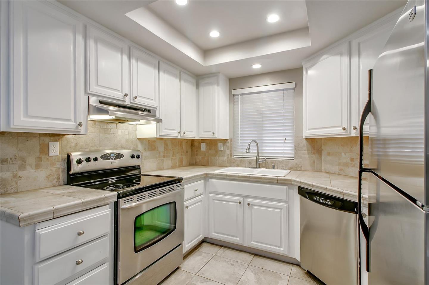 275 Shadow Dance Drive San Jose, CA 95110 - Photo 9 of 31 a kitchen with white cabinets stainless steel appliances and sink