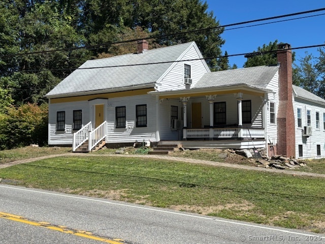 a view of a white house with a big yard and large windows