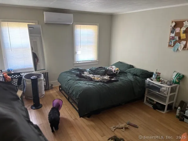a bed sitting in a bedroom next to a window and a chair
