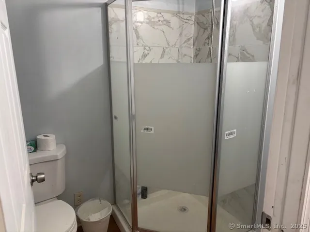 a bathroom with a toilet and a shower