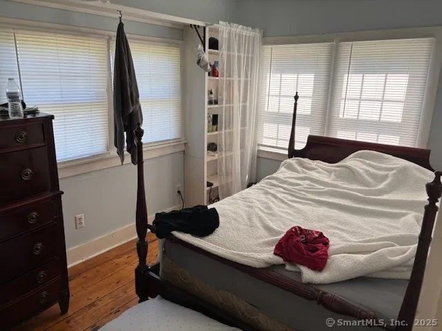 a bedroom with a bed and wooden floor