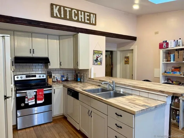 a kitchen with stainless steel appliances granite countertop a sink stove and cabinets