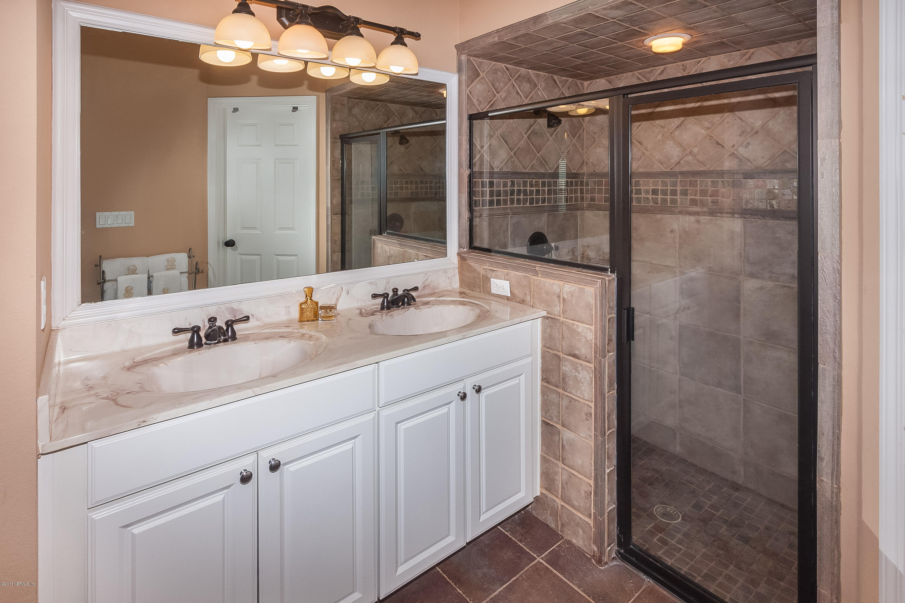 7713 Palmo Fish Camp Road St. Augustine, FL 32092 - Photo 14 of 35 a bathroom with a shower sink and mirror