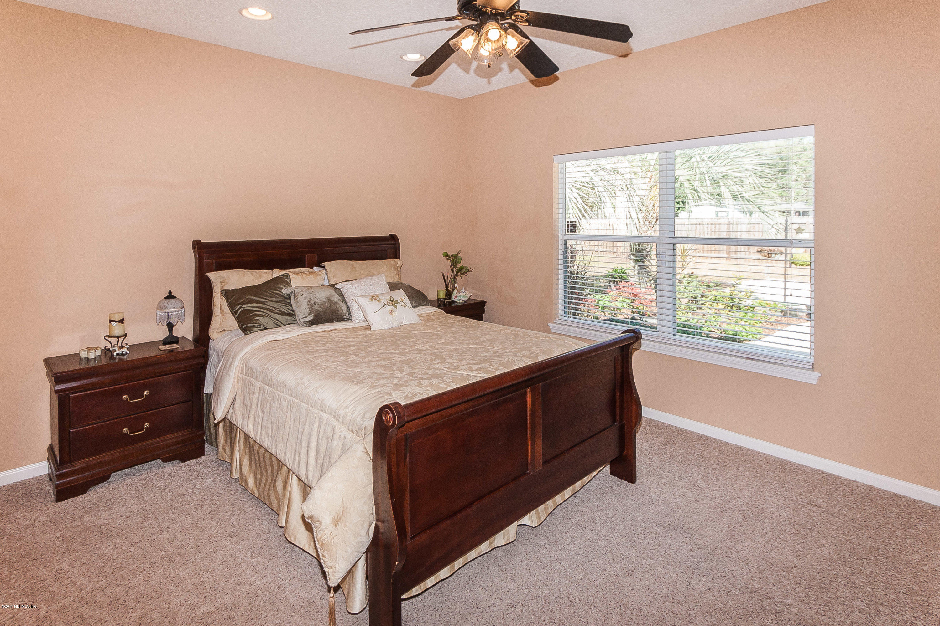 7713 Palmo Fish Camp Road St. Augustine, FL 32092 - Photo 15 of 35 a spacious bedroom with a bed and a chandelier