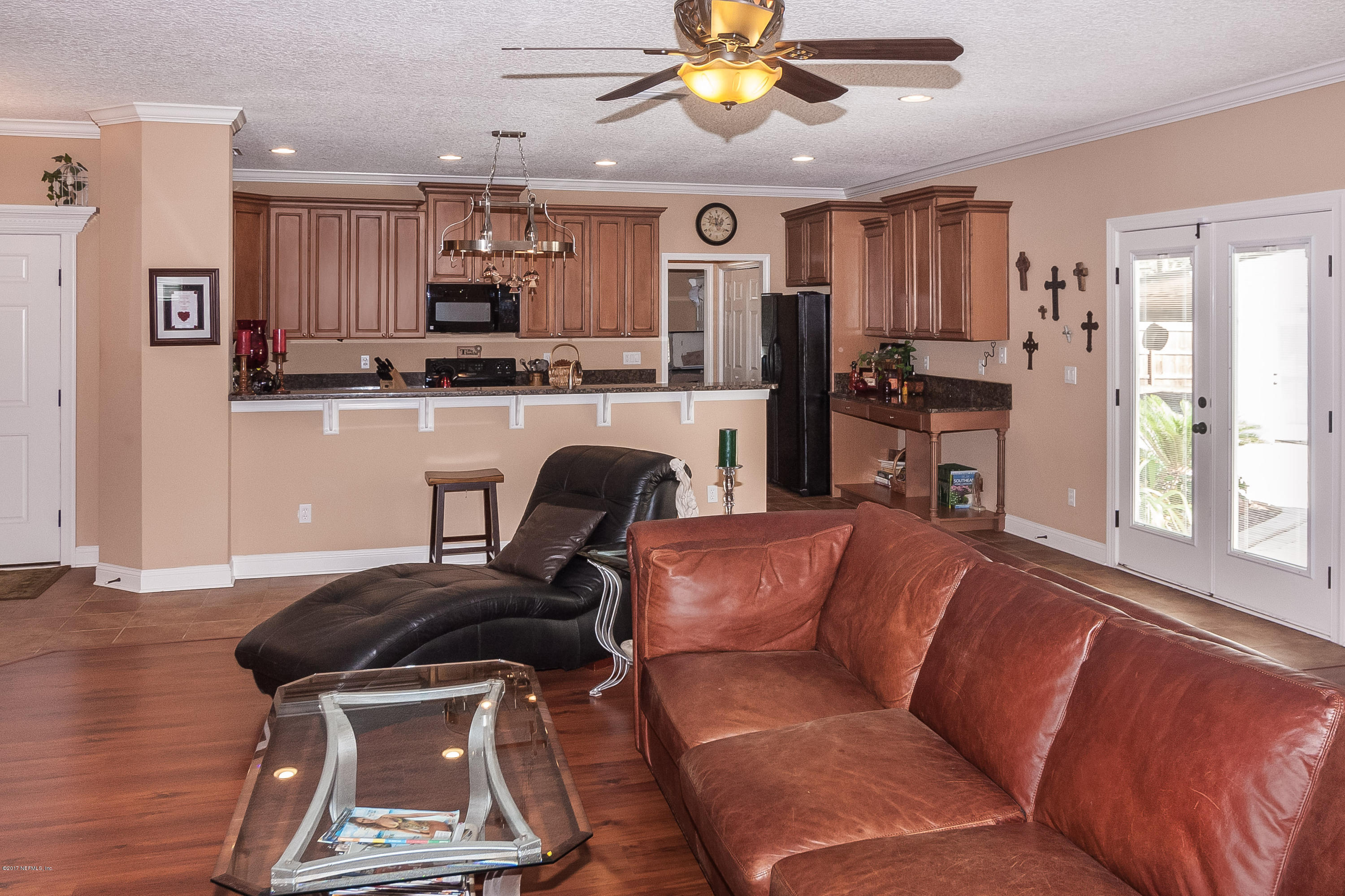 7713 Palmo Fish Camp Road St. Augustine, FL 32092 - Photo 6 of 35 a living room with stainless steel appliances kitchen island granite countertop furniture and a window
