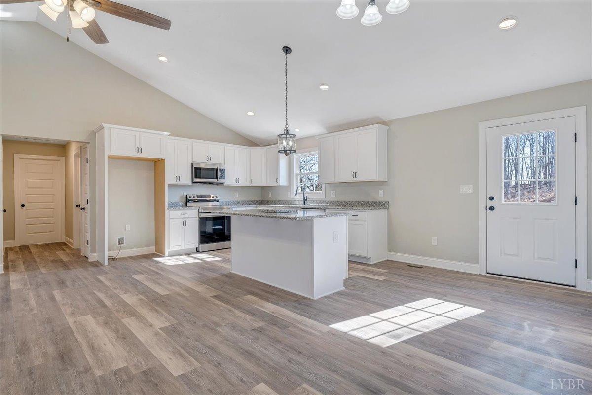 5934 Joppa Mill Road Moneta, VA 24121 - Photo 12 of 45 a large kitchen with granite countertop a stove a sink dishwasher and a refrigerator with wooden floor