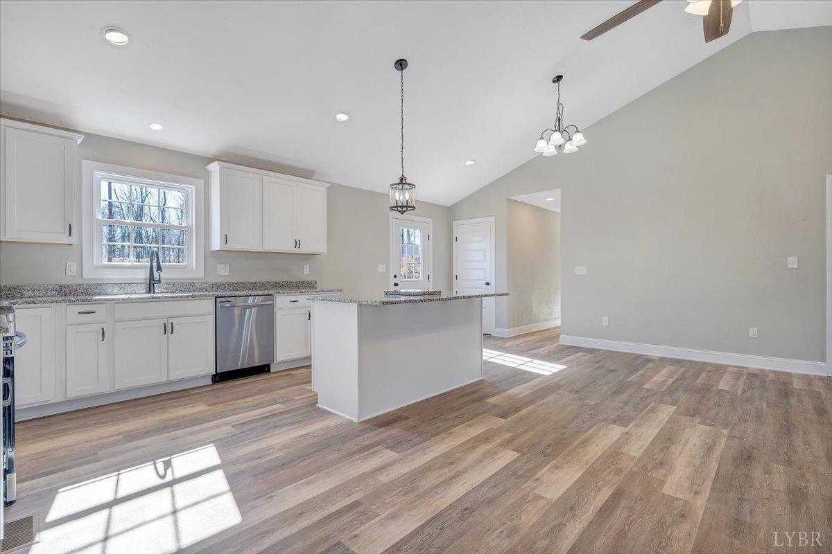 5934 Joppa Mill Road Moneta, VA 24121 - Photo 7 of 45 a large kitchen with granite countertop a stove a sink dishwasher a refrigerator white cabinets and wooden floor next to a window