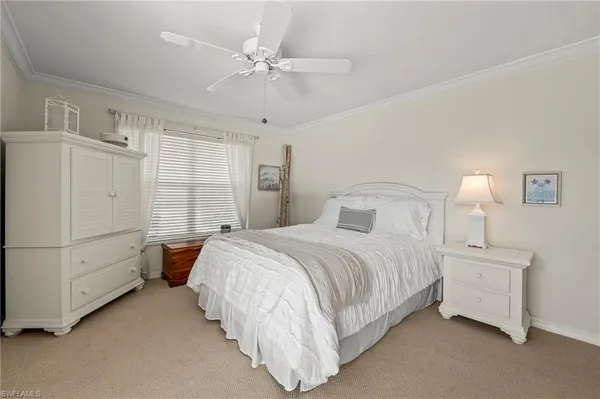 a spacious bedroom with a bed and a chandelier