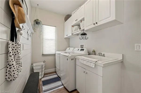 a utility room with cabinets washer and dryer