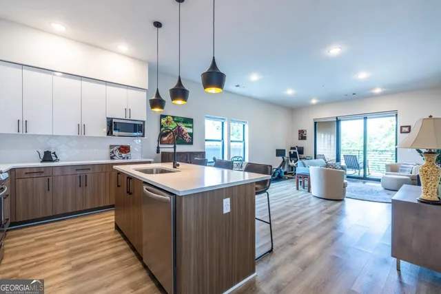 a kitchen that has a lot of cabinets in it and wooden floors