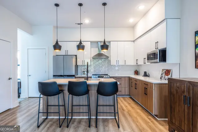 a kitchen with stainless steel appliances granite countertop a kitchen island a stove and a refrigerator