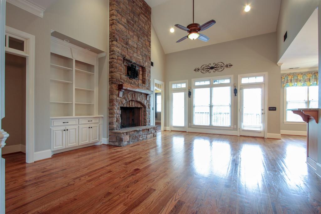 7127 Old Franklin Road Fairview, TN 37062 - Photo 7 of 30 wooden floor in an empty room with a fireplace and a large window