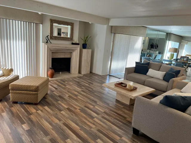 a living room with a fireplace and potted plant