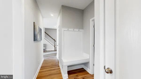 a view of a hallway with wooden floor and entryway