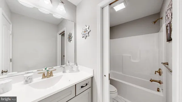 a bathroom with a granite countertop sink a toilet and shower