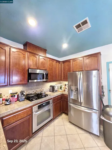 a kitchen with stainless steel appliances granite countertop a refrigerator sink and stove