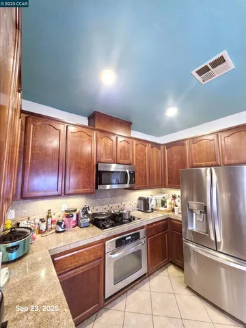 a kitchen with a refrigerator sink and cabinets