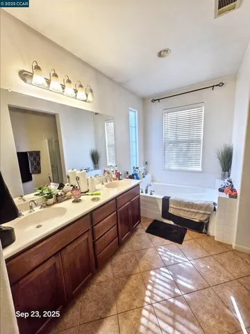a spacious bathroom with a bathtub sink and mirror
